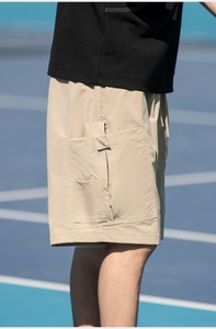 Detail view of khaki cargo shorts with large side pockets for summer outdoor activities