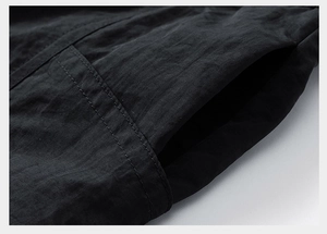 Detail of side slash pocket and double-needle stitching on black streetwear shorts