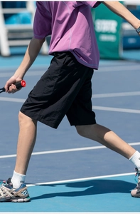 Vista laterale dei pantaloncini sportivi neri da uomo con tasca nascosta sul campo da tennis