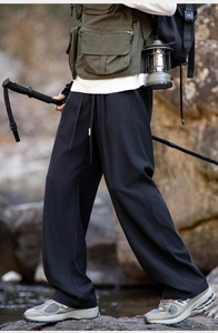 Detail of loose black outdoor trousers with adjustable drawstring waist and ice silk fabric