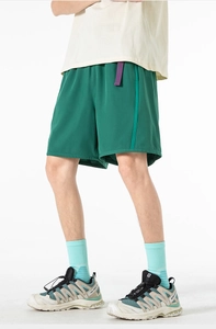 Detailed view of dark green cargo shorts with vertical side stripes and purple belt detail