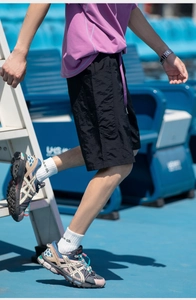 Dettaglio dei pantaloncini cargo neri traspiranti in nylon leggero per uomo sportivo