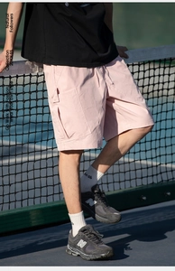 Detail of pink cargo shorts with elastic drawstring waist and side flap pockets