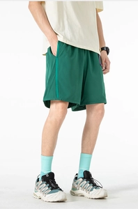Detailed close-up of green men's quick-dry cargo shorts with side ribbon trim