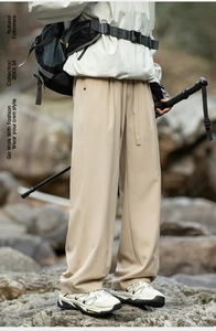 Close-up of khaki outdoor hiking pants with drawstring waist on rocky river background