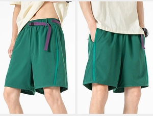 Detail view of dark green cargo shorts featuring purple woven belt and utility buckles