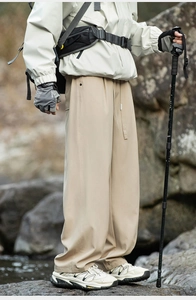 Close-up of beige outdoor hiking pants with drawstring waist and functional side pockets