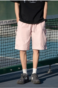 Detail of pink cargo shorts featuring large utility pockets and elastic drawstring waist