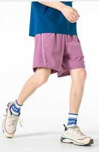 Detail of purple quick-dry cargo shorts featuring lateral stripes and lightweight fabric
