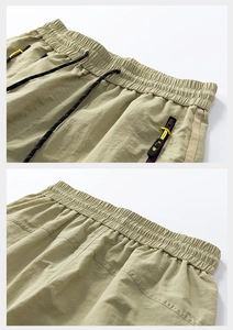 Detail view of olive green sports shorts with adjustable drawstring and hidden zipper pocket