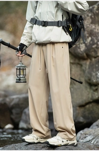 Detail of khaki hiking trousers with elastic waist and drawstrings for outdoor camping