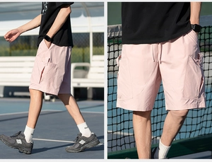 Detail of pink cargo shorts with side pockets and elastic waist on tennis court