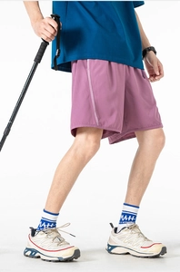 Detail view of pink athletic shorts featuring elastic waistband and side stripe paneling