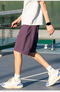Dettaglio dei pantaloncini viola in tessuto effetto ghiaccio da uomo su campo da tennis