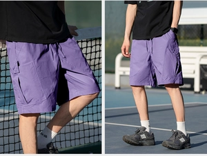 Detail of purple cargo shorts featuring side flap pockets and elastic drawstring waist