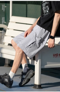 Detail view of light grey cargo shorts featuring functional 3D flap pockets on side