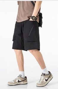Dettaglio dei pantaloncini cargo neri da uomo con coulisse in vita e tasca con zip