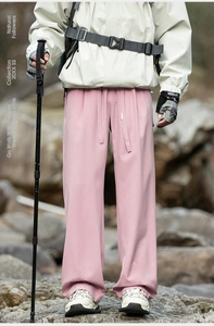 Detail of pink wide-leg hiking pants with drawstring waist and smooth technical fabric texture
