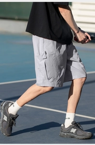 Detail of grey cargo shorts with large side pockets and elastic drawstring waistband
