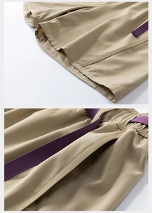 Detail of khaki cargo shorts showing elastic waistband with purple drawstring and hem stitching