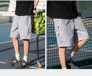 Detail of light gray cargo shorts with large side pockets and drawstring waist in sports setting