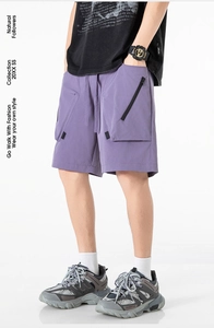 Dettaglio dei pantaloncini cargo viola con tasca funzionale con zip nera e vita elastica