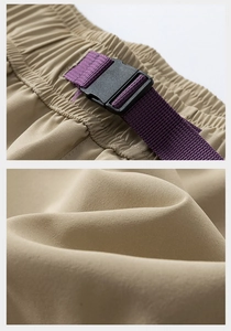 Detail of khaki cargo shorts with purple nylon webbing strap and black buckle closure