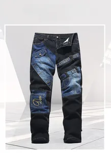 Detail der Patchwork-Jeans mit blauen Einsätzen und besticktem KOSMO UPC Band