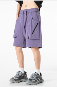 Dettaglio di pantaloncini cargo viola techwear con vita elastica e tasche 3D utility