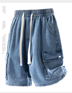 Détail de la taille élastique avec cordon blanc sur un short cargo en jean bleu