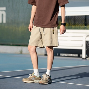 Men's khaki ice-skin cargo shorts with adjustable drawstring on a tennis court