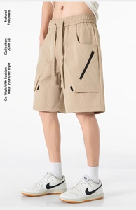 Dettaglio di pantaloncini cargo kaki con vita elastica a coulisse e tasca con cerniera