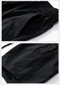 Detail of black cargo shorts featuring elastic drawstring waist and reinforced stitching