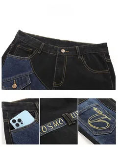 Detailaufnahme der blauen Patchwork-Jeans mit goldener Stickerei und Logo-Nähten am Bund