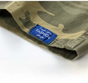 Detailed macro view of camo cargo shorts leg showing reinforced stitching and brand label