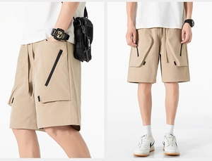 Dettaglio dei pantaloncini cargo kaki con tasche laterali a zip e vita con coulisse regolabile