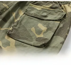 Detailed close-up of jungle camouflage cargo shorts with flap pocket and reinforced stitching