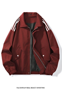 Detail of burgundy zip-up jacket featuring classic white shoulder stripes and flap pockets
