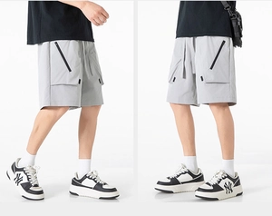 Dettaglio dei pantaloncini cargo da uomo con tasche laterali dotate di zip nera
