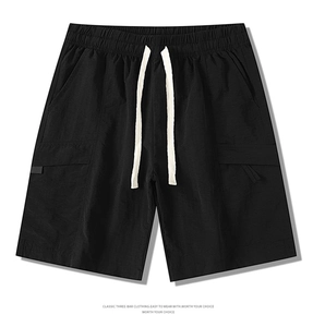 Detail of black cargo shorts featuring elastic waistband and white contrast drawstring