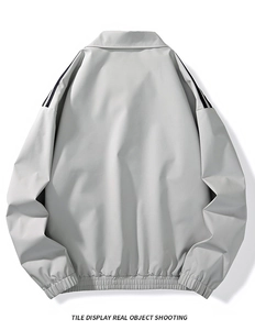 Flat lay of light gray casual jacket featuring black shoulder stripes and elastic hemline