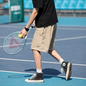 Mens khaki cargo shorts in casual loose fit with large utility pockets on blue court