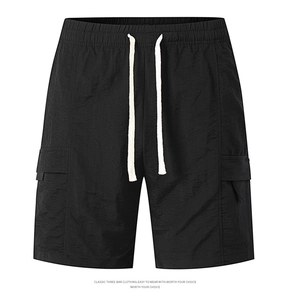 Detail of black cargo shorts featuring elastic waist with drawstrings and side flap pockets