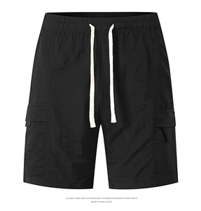 Detailed view of black cargo shorts featuring elastic drawstring waist and flap pockets
