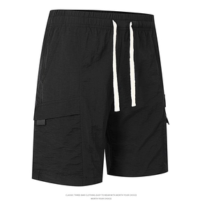 Detail view of black cargo shorts featuring elastic drawstring waist and large flap pockets