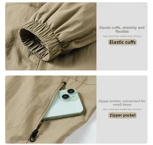 Detail view of elastic cuffs and secure zipper pockets on khaki waterproof jacket