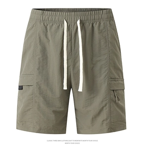 Detail view of military green cargo shorts featuring drawstring waist and side flap pockets