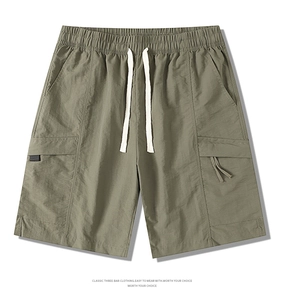 Detail of army green nylon cargo shorts showing elastic waistband and drawstring