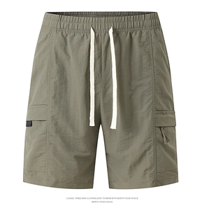 Detail of army green nylon cargo shorts showing elastic waistband and drawstring texture