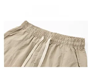 Detail view of khaki casual shorts with elastic waistband and adjustable white drawstring